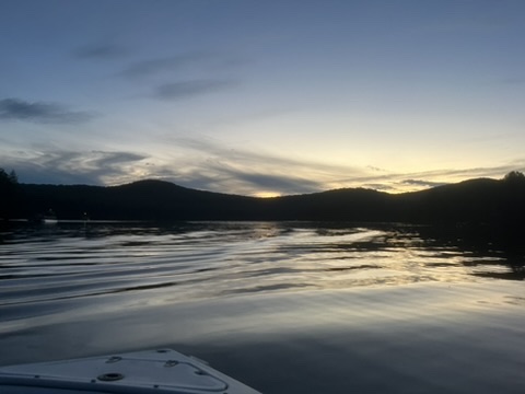 Dusk at Martin's Pond in Peacham, VT. Picture shows sun setting behind the mountains and reflecting off the water